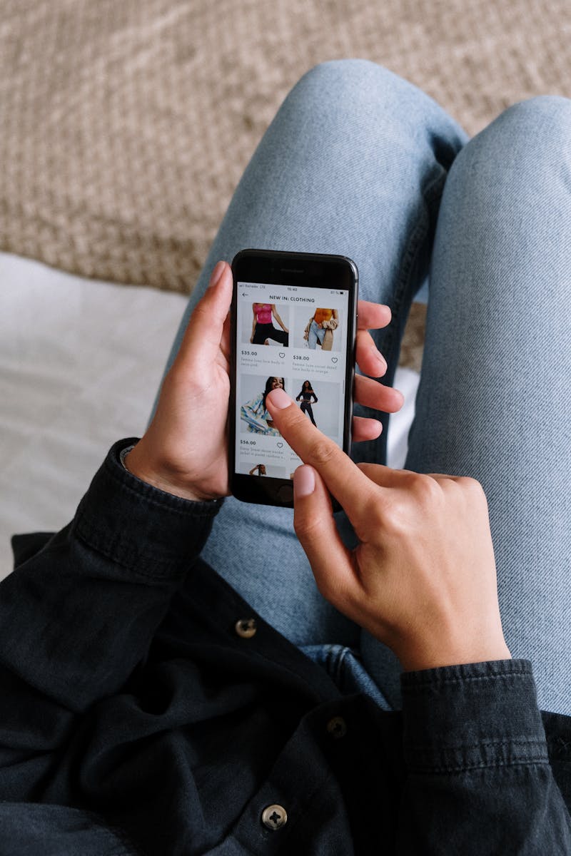 Person browsing clothing listings with prices on a mobile app