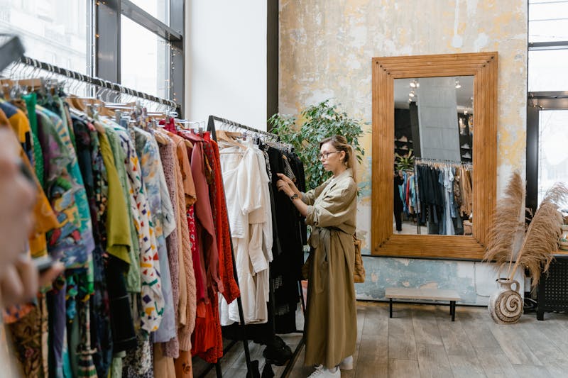 Woman browsing secondhand clothing at a vintage thrift store